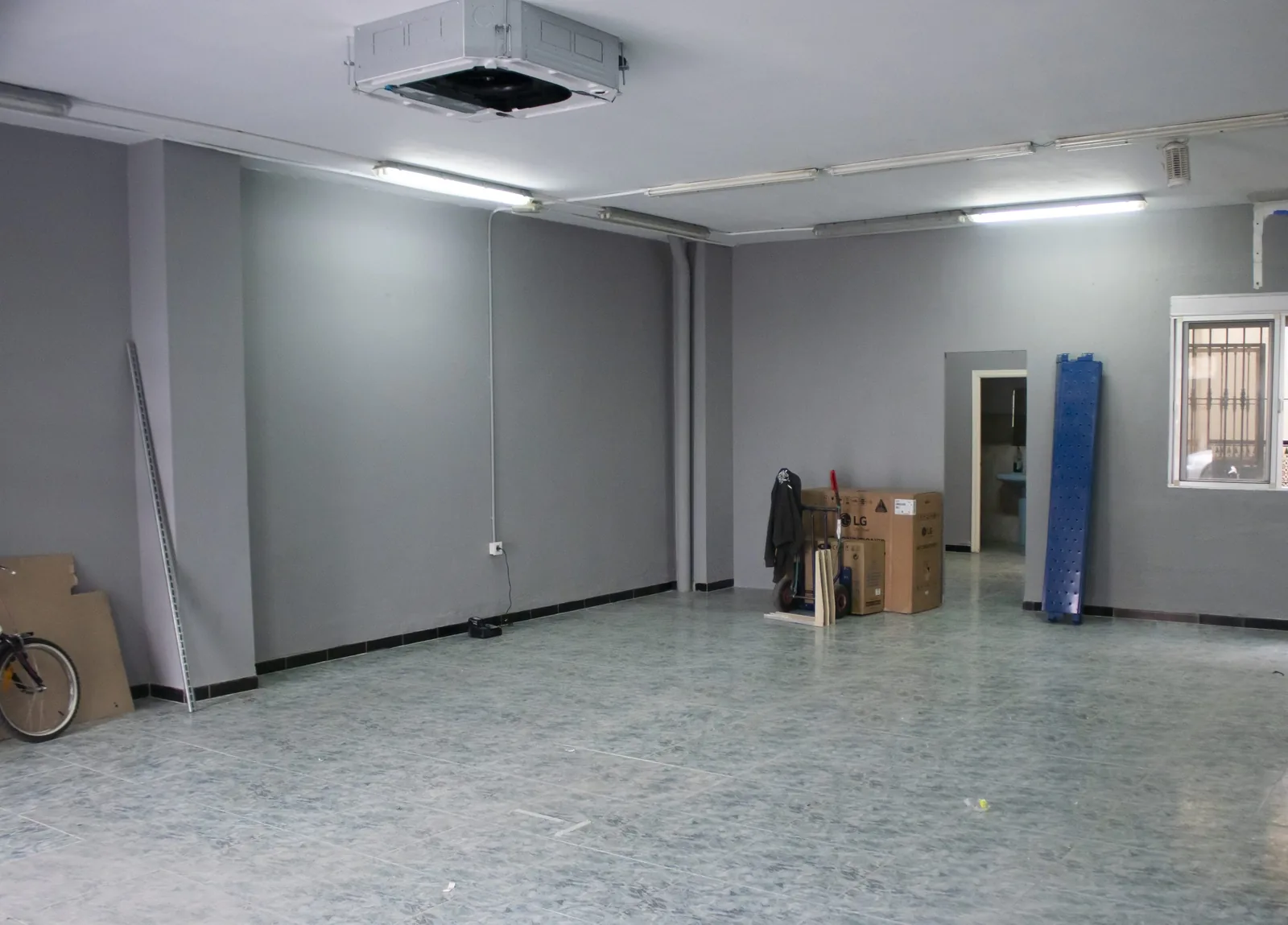 Estanco en Salteras (Sevilla) antes de la reforma: local vacío con paredes grises y fluorescentes